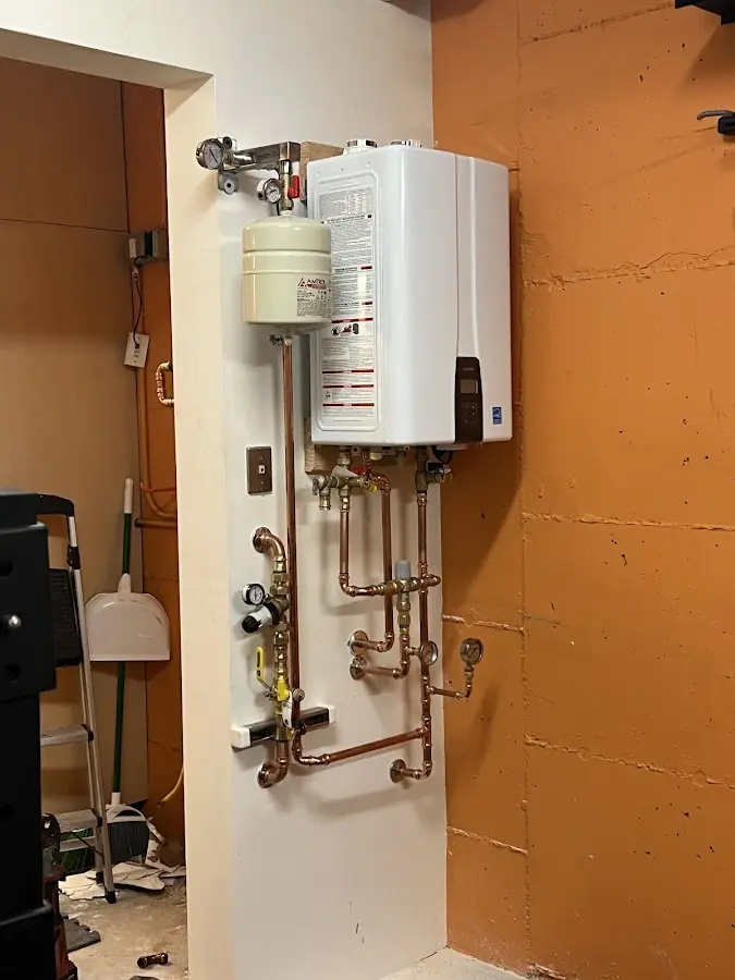 Plumbing technician inspecting water heater connections in Farmerville